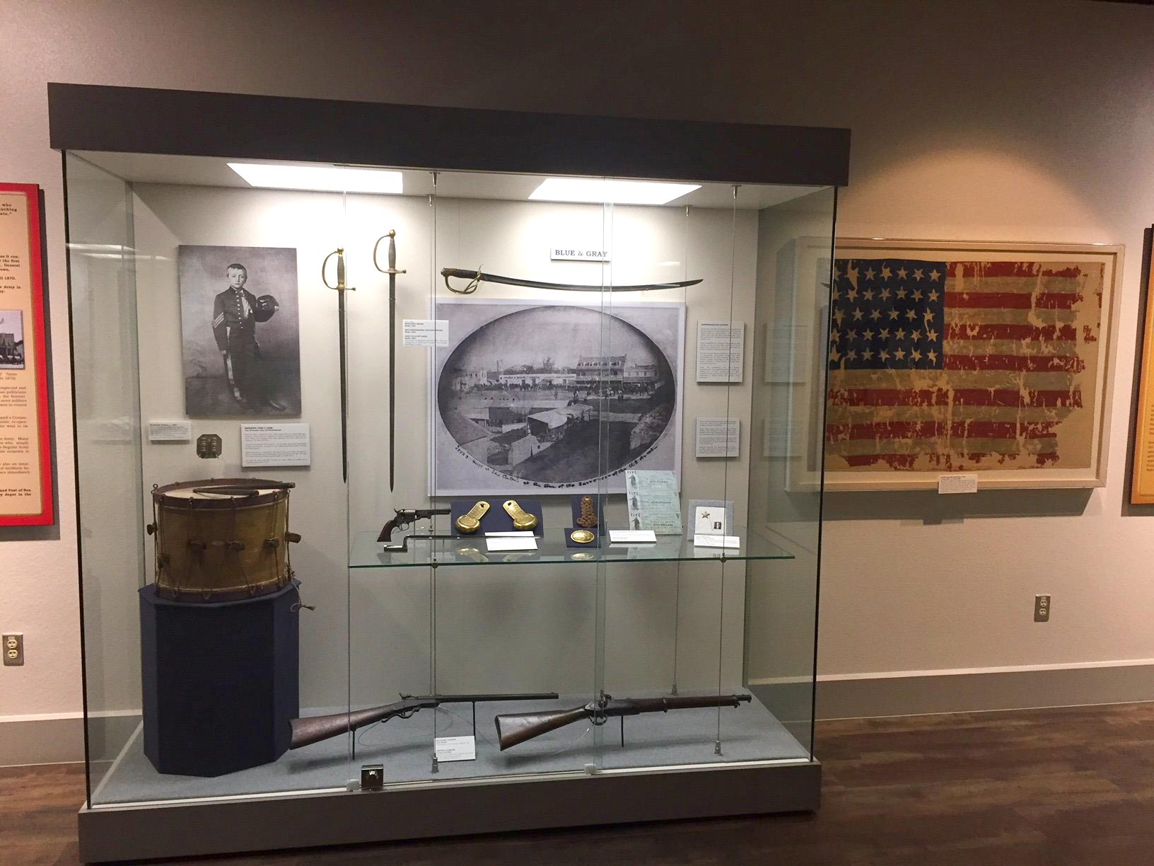 A museum exhibit featuring artifacts inside a glass enclosure at the Fort Sam Houston Museum.